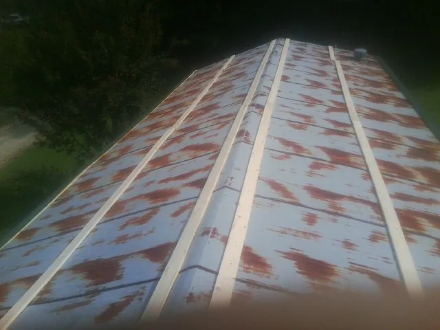 Rusted metal roof panels with new wood purlins before replacement — Storm Damage Roof Repair in Navasota by Roofing Brothers
