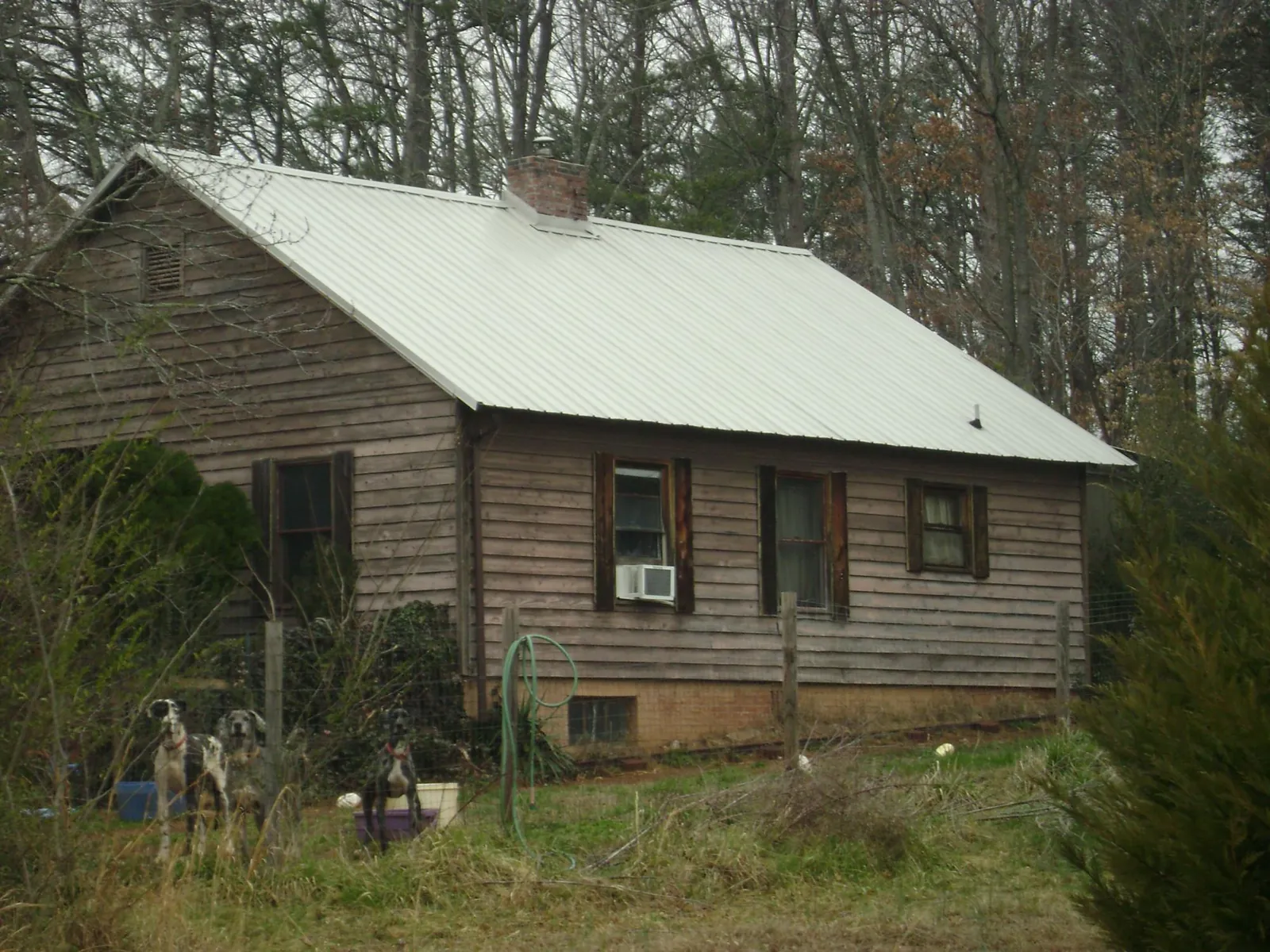White metal roof on an old wood sided farmhouse, from a Asphalt Shingle Roof Repair job in Navasota